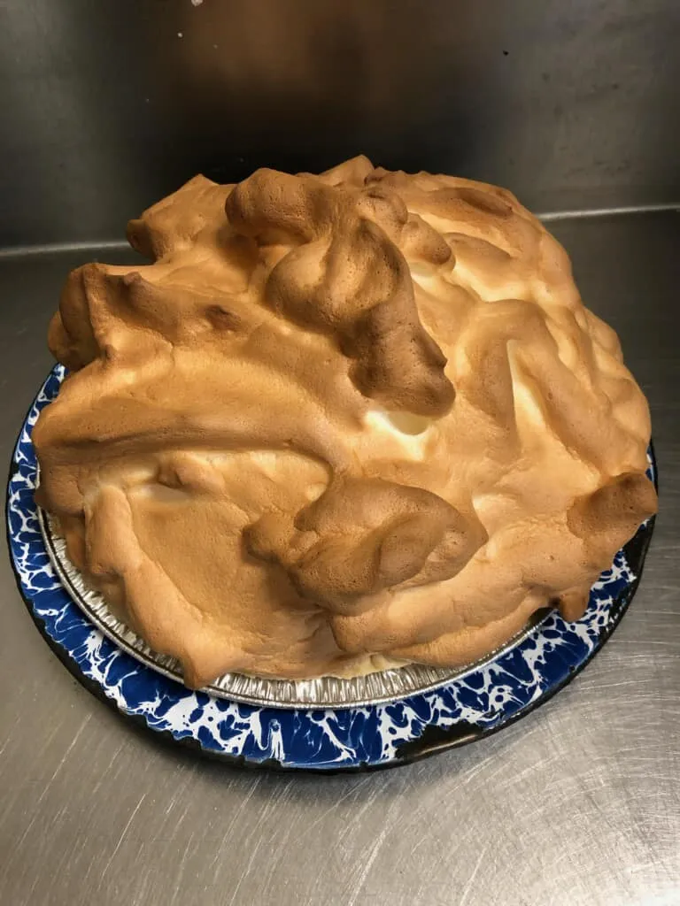 A meringue pie on a blue enamel plate
